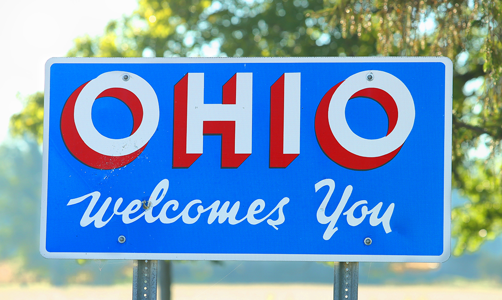 Welcome to Ohio sign along a rural farm road at the Ohio/Michigan state line.